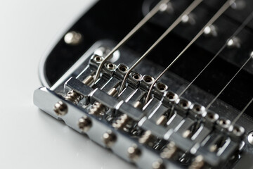 Fototapeta na wymiar Electrical guitar bridge and metal strings closeup. Electric guitar black and white color, detail. Music instruments. Concept international music day. Macro
