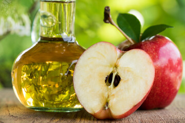 Apple fruit and Apple Cider Vinegar on nature background.