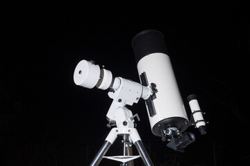Photo of a telescope on a black background.