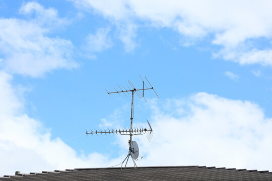 青空の屋根に立つテレビアンテナ