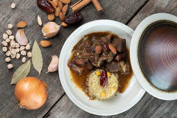 Slow cooked lamb with potato and dates served with warm couscous and chickpeas isolated on the...