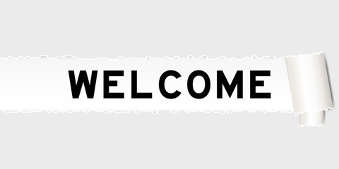 Ripped gray paper that have word welcome under torned part