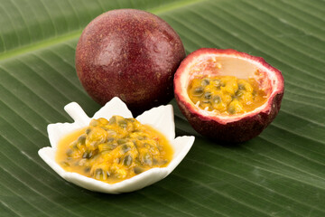 Passion fruit or passiflora edulis fruits on banana green leaf background.