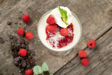 Top view of whipped cream, milk, raspberry, vanilla and raspberry sauce isolated on the wooden table