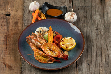 Wok-fried prawns with garlic and chili isolated on wooden rustic table