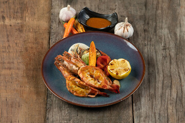 Wok-fried prawns with garlic and chili isolated on wooden rustic table