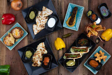 Top view variety of delicious starters from around the world isolated on rustic wooden table