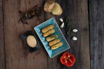 Top view of deep fried crab potato croquettes with roasted pepper Aioli sauce isolated on wooden table © stryjek