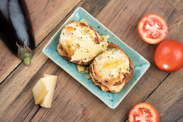 Pan fried crispy eggplant with parmesan cheese crust isolated on wooden table