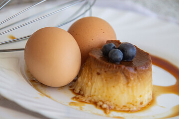 delicious egg custard with caramel and blueberries on the white plate