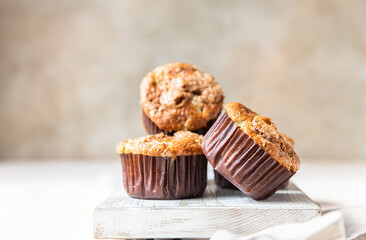 Tasty breakfast muffins with oat crumbs topping on white cutting board, light concrete background. 