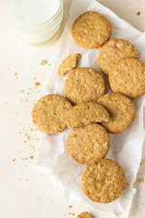 Healthy oatmeal or multigrain cookies with seeds and nuts on baking paper, light concrete background. Selective focus. Top view. 
