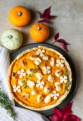 Top view of pumpkin tart or pie with feta cheese and thyme. Fall season concept. Cozy autumn food background. 