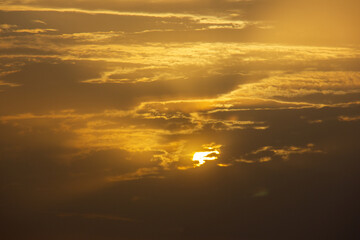 A beautiful sunset on a cloudy day. 
Cloudy sunset on a summer day.
A view of sun peaking through the clouds. 