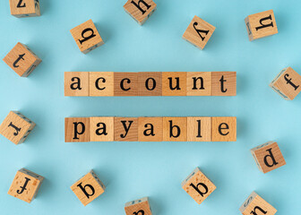 Account Payable word on wooden block. Flat lay view on blue background.