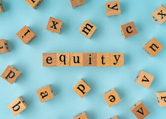 Equity word on wooden block. Flat lay view on blue background.