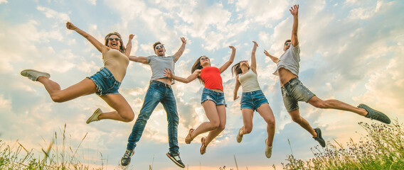 The happy people jumping on the background of the clouds - Powered by Adobe
