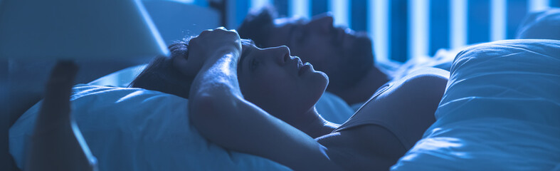 The woman with headache lay near the man. night time
