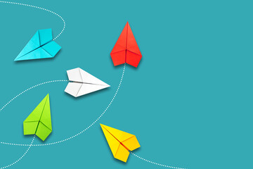 Red paper plane flying in a different direction than multicolored. Blue background. Copy space. The...