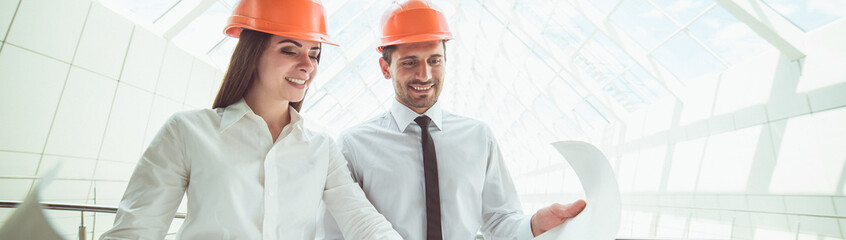 The two engineers hold the project plan in the building