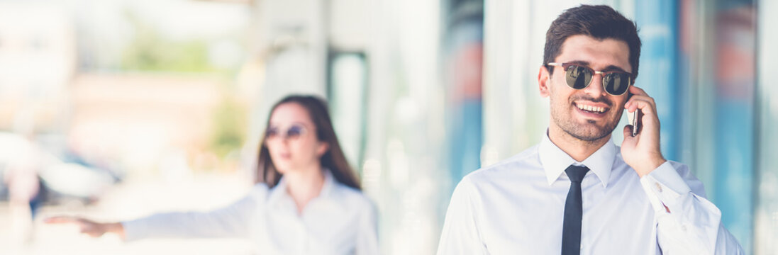 The handsome businessman in sunglasses phone near the woman