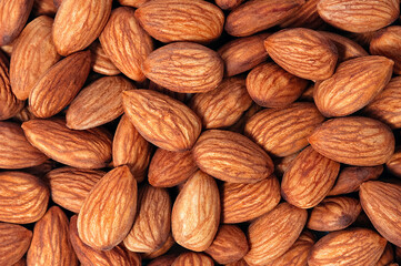 Background of almonds. Fried almonds. Scattered almond grains. Background for advertising