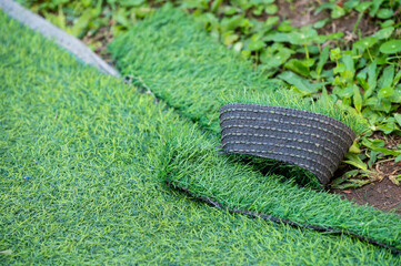 Green artificial turf used for covering sport arena or garden. Artificial grass are made by...