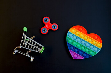 Top view of colorful anti stress sensory toy pop it rainbow heart on black background close up. And...