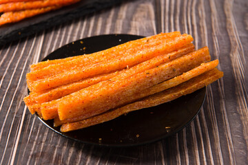 Chinese street snacks.Article spicy,Spicy gluten latiao on wood background