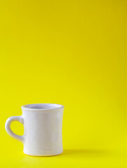 Cup of coffee on yellow background
