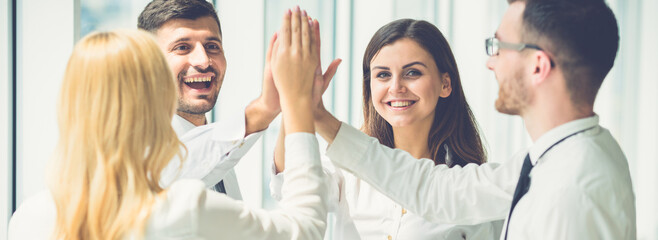 The four business people greeting with a high five