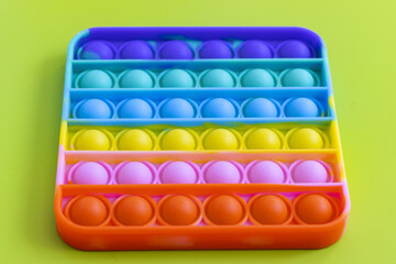 anti-stress toy pop it on the green background. Colorful poppit toy, bubble fidget, simple-dimple