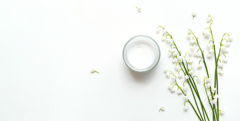 Healthy organic cosmetic product, wellness and relaxation lotion in glass jar on white background. Natural cosmetics, skin care product facial cream with flowers. 