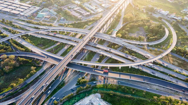 Aerial view of road interchange or highway intersection with busy urban traffic speeding on the road. Junction network of transportation taken by drone.
