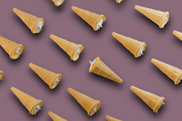 Waffle cones with white sweet filling on a gray-pink background. Sweet waffle cones with filling. The image of a sweet treat.