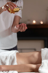 A massage therapist doing a massage with oil to another woman