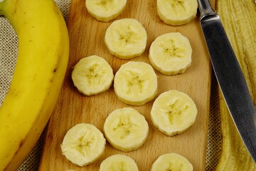 Sliced banana lies on a wooden board 