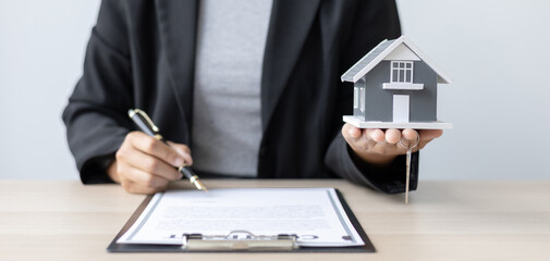 Sales manager or salesperson holds a demo house and has a home purchase contract with keys to...