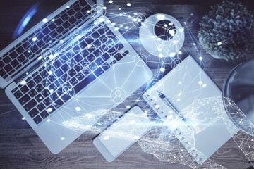 Social network hologram drawings over computer on the desktop background. Top view. Double exposure.