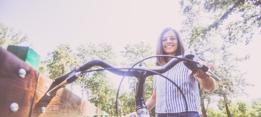 Pretty Young Woman Riding Bicycle In The Park