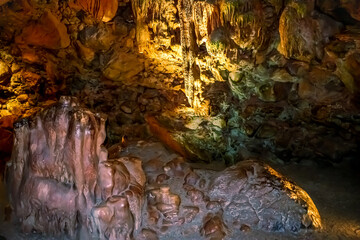 Stone walls with mineral formations inside Damlatas cave in Alanya (Turkey). Natural abstract geological background, close-up