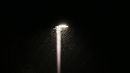 Straßenlaterne verschwimmt im Starkregen eines Sommergewitters