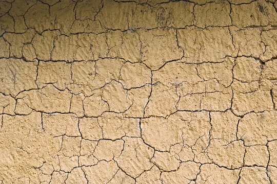 Mud wall texture background. Cracks in a mud wall. Yellow wall. Wall made with bahareque