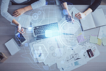 Double exposure of woman hands working on computer and social network theme hologram drawing. Top...