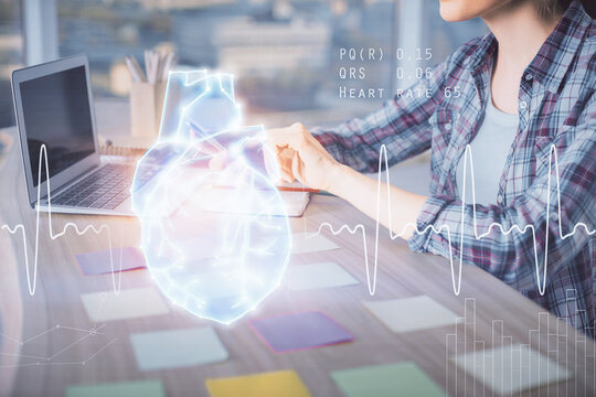 Double exposure of woman hands typing on computer and heart hologram drawing. Education concept.