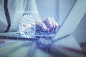 Double exposure of woman hands typing on computer and fingerprint drawing. Security concept.