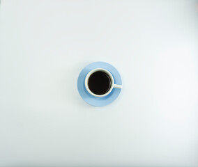 Hot coffee in a white ceramic cup with a blue glass base