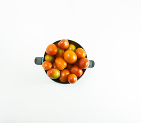 Fresh tomatoes placed in a stainless bowl on a white background
