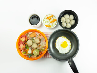 Omelet, pickled cucumber meatballs and meatball soup on a napkin on a white background