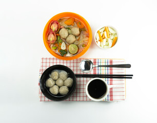 Pickled cucumber meatballs and meatball soup on a napkin on a white background